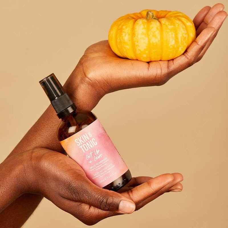 woman holding skin and tonic jelly cleanser with a pumpkin