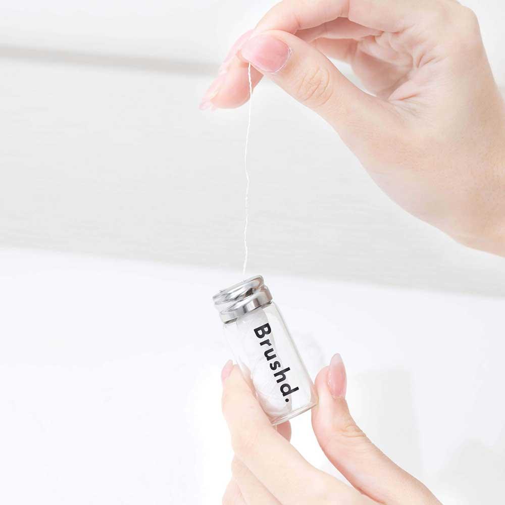 woman using brushd corn dental floss