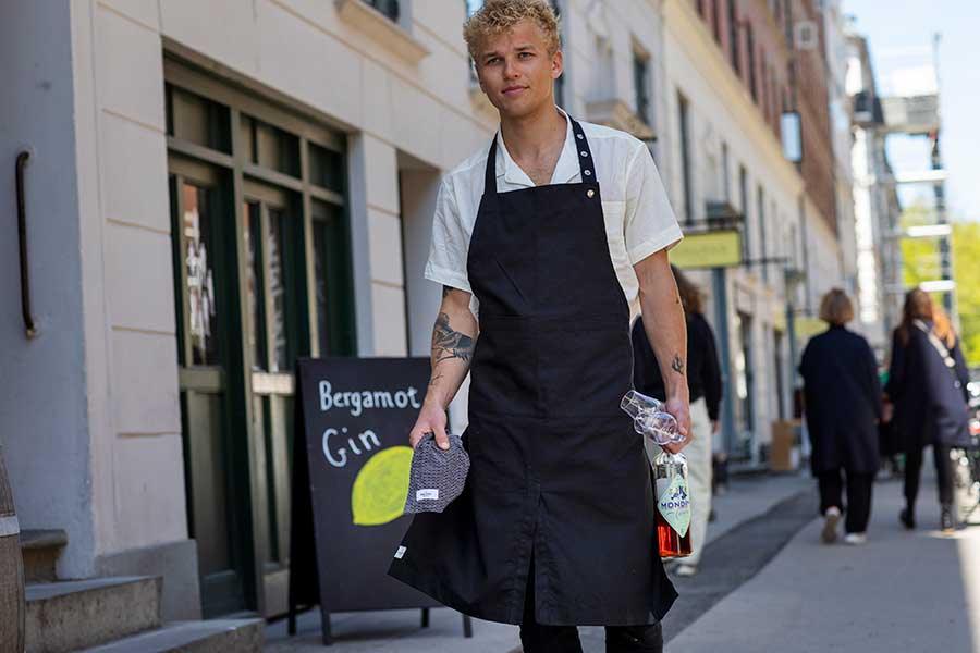 man walking down the street in an organic cotton apron