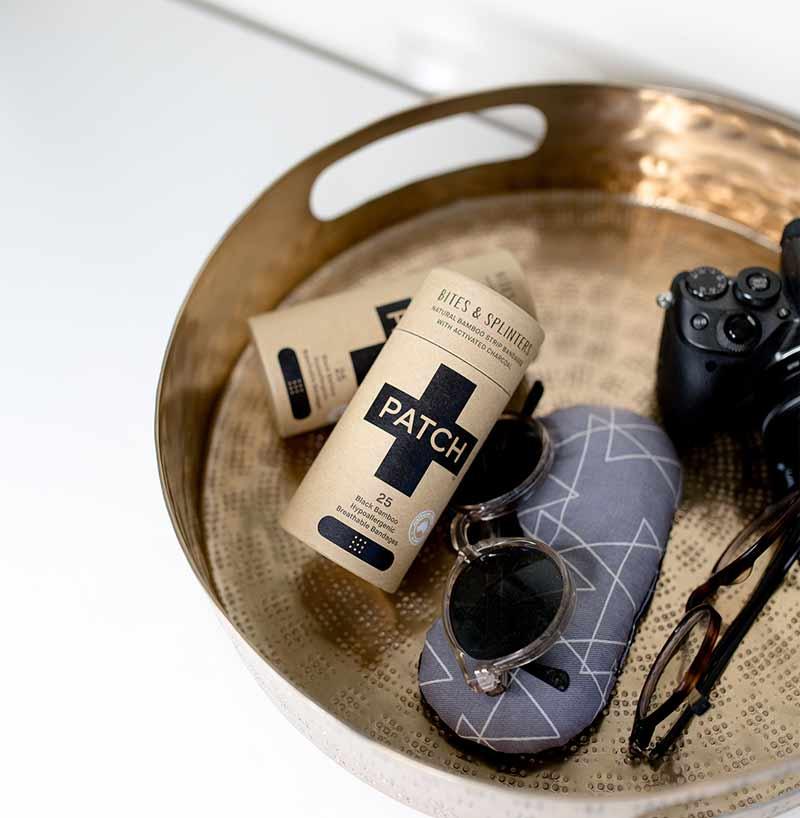 plastic free plasters on a golden tray with sunglasses