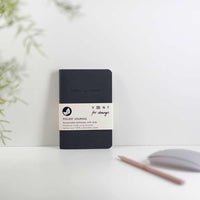 charcoal grey recycled leather pocket journal standing on desk