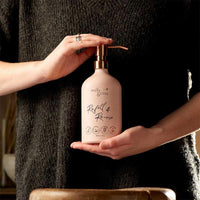 woman holding a aluminium pump bottle