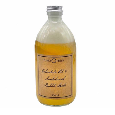 calendula and sandalwood oil in glass bottle