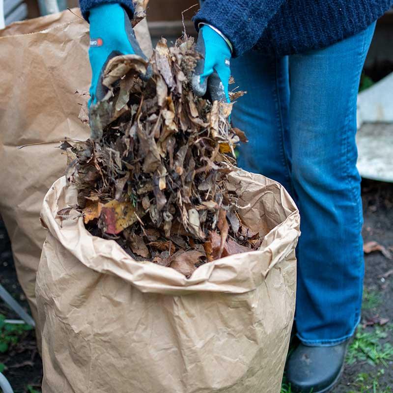 woman filling compostable garden waste bag