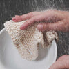 cleaning a dirty bowl with a sustainable dish scrubber
