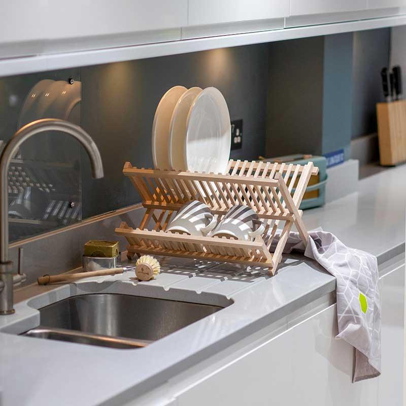 wooden dish drainer next to a sink