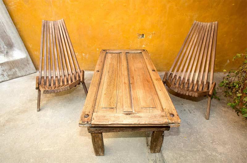 reclaimed garden furniture against yellow wall