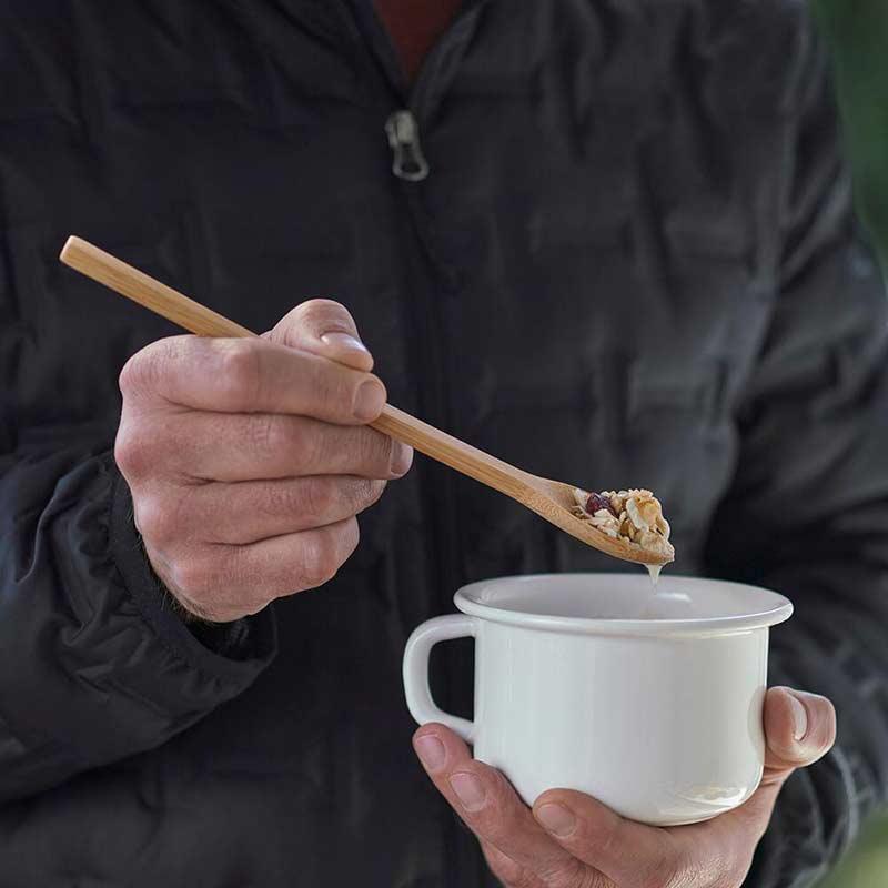 man using a long handle bamboo spoon