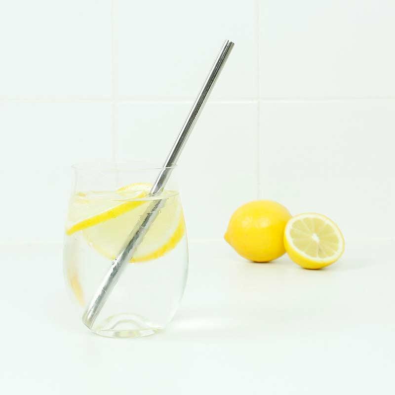 reusable metal straw in a glass of water