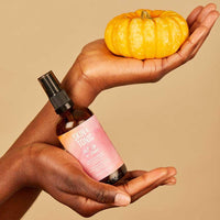 woman holding skin and tonic jelly cleanser with a pumpkin