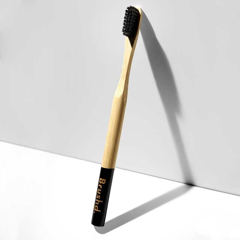 adult bamboo toothbrush leaning on a wall