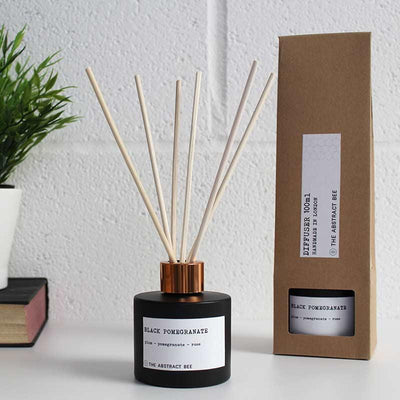 black pomegranate reed diffuser next to packaging