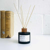 natural reed diffuser next to books