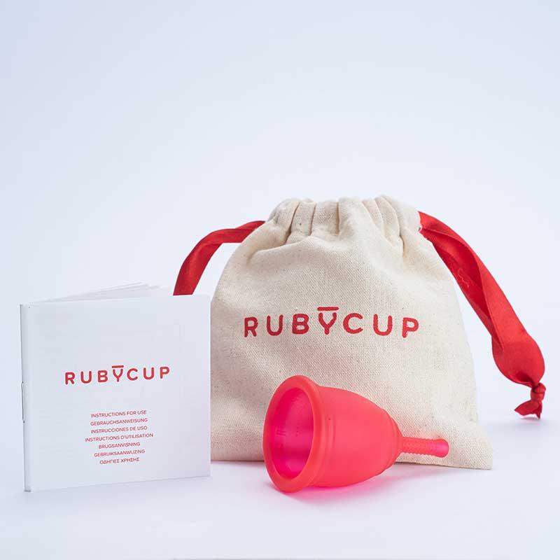 red ruby cup menstrual cup beside drawstring pouch