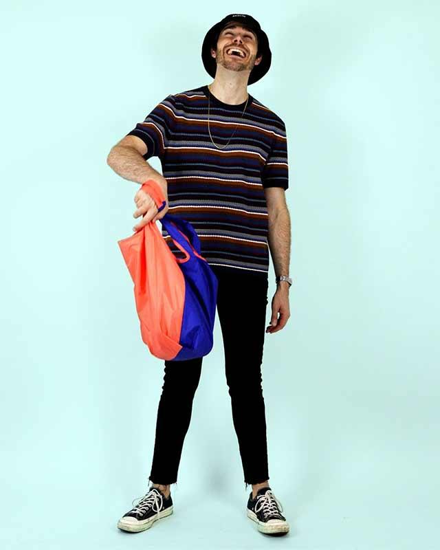 man holding bicolour shopping bag
