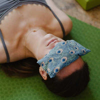 woman doing yoga with eye pillow