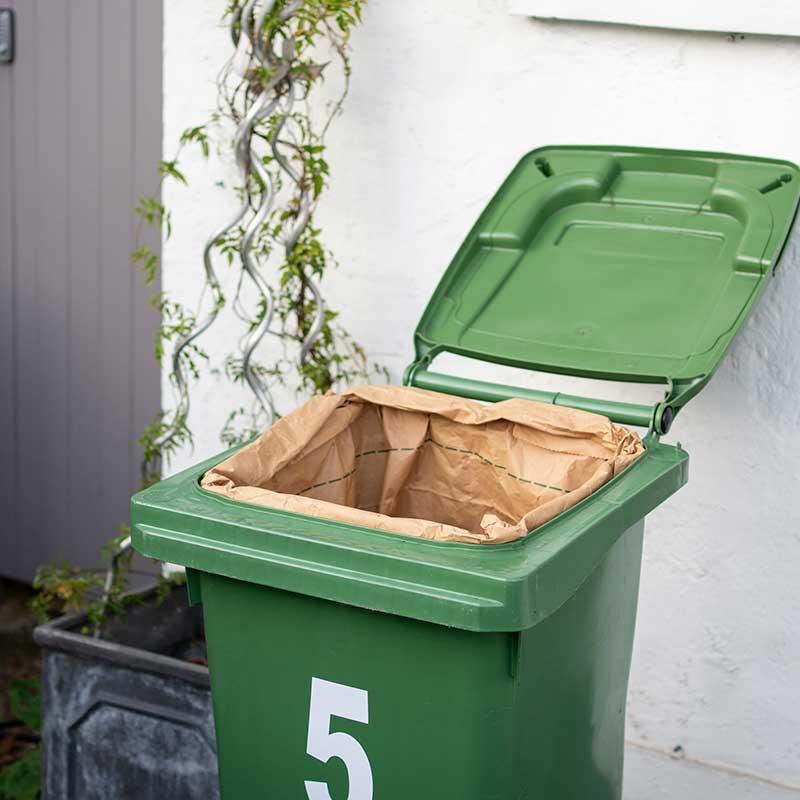 green wheelie bin with wheelie bin liner inside