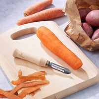 wooden vegetable peeler on a chopping board