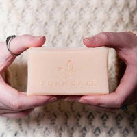 woman holding handmade bar of soap in hands