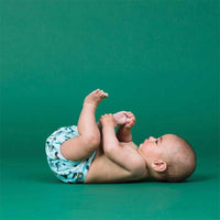 baby wearing a reusable nappy with green background