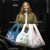 woman holding 3 reusable shopping bags