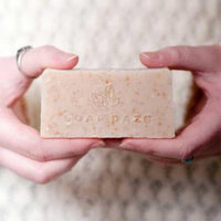 woman holding sustainable soap bar without packaging