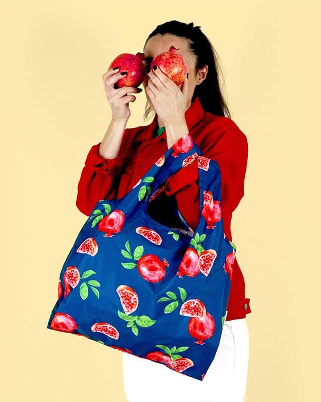 woman holding a pomegranate shopping bag