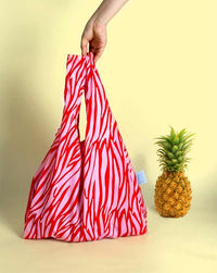 red reusable bag next to pineapple